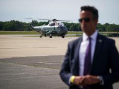 Marine One, carrying U.S. President Joe Biden, arrives past a U.S. Secret Service agent standing guard, as Biden arrives for a weekend trip to his home in Wilmington at Delaware Air National Guard Base
