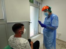 Una sanitaria, ayer realizando una PCR en el centro habilitado en un antigua guardería de Huesca.