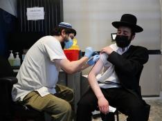 Un enfermero israelí inocula con la tercera dosis de la vacuna a un ciudadano
