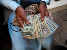 Foto de recurso de un ciudadano afgano contando dinero en dólares