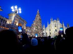 Decenas de personas fotografían el gran árbol de Navidad en la plaza de la catedral de Milán