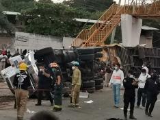 Rescatistas y autoridades trabajan en la zona del accidente de un camión donde viajaban migrantes.