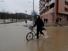 Un vecino atraviesa una calle inundada en el barrio pamplonés de la Rochapea.