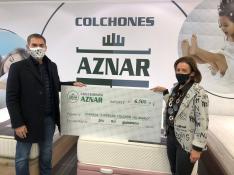 El presidente de Aspanoa, Gabriel Tirado, recibe el cheque solidario de manos de la gerente de Colchones Aznar, Carmen Cabeza.