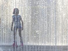 Una niña se refresca en una fuente de Zaragoza durante una de las tres olas de calor de este verano.