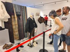 Los visitantes observan los detalles de las prendas expuestas en 'El vestir de la Litera'.