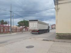 Un camión pasa por la travesía de Aguaviva por delante del colegio público de la localidad.