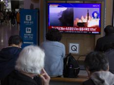 Varios ciudadanos siguen por televisión desde Seúl el lanzamiento de los misiles