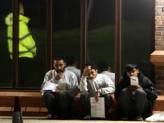 Tres migrantes afganos esperando a volver al centro de Manston, en Reino Unido.