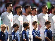 Los jugadores de Irán se alinean durante el himno nacional antes del partido.