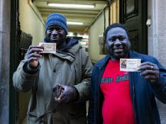 Dos ciudadanos gambianos en la administración de loterías agraciada en Olot