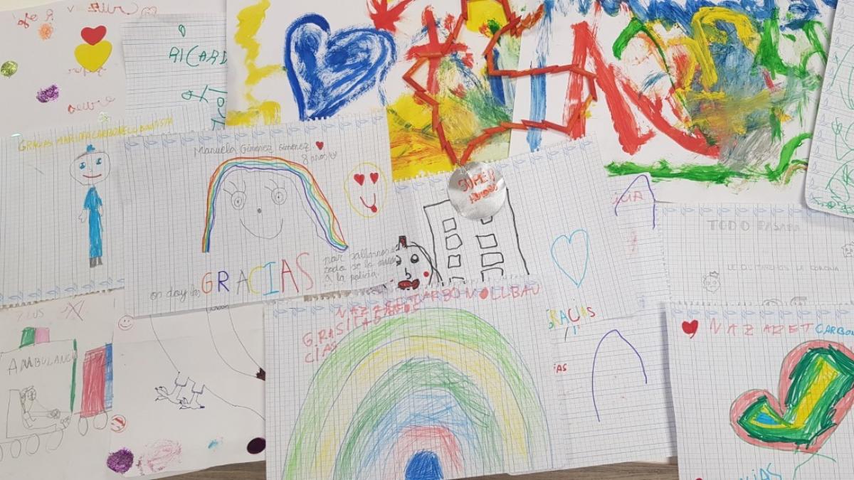 Lluvia de dibujos de los niños de una calle de Huesca al paso de  ambulancias de Cruz Roja