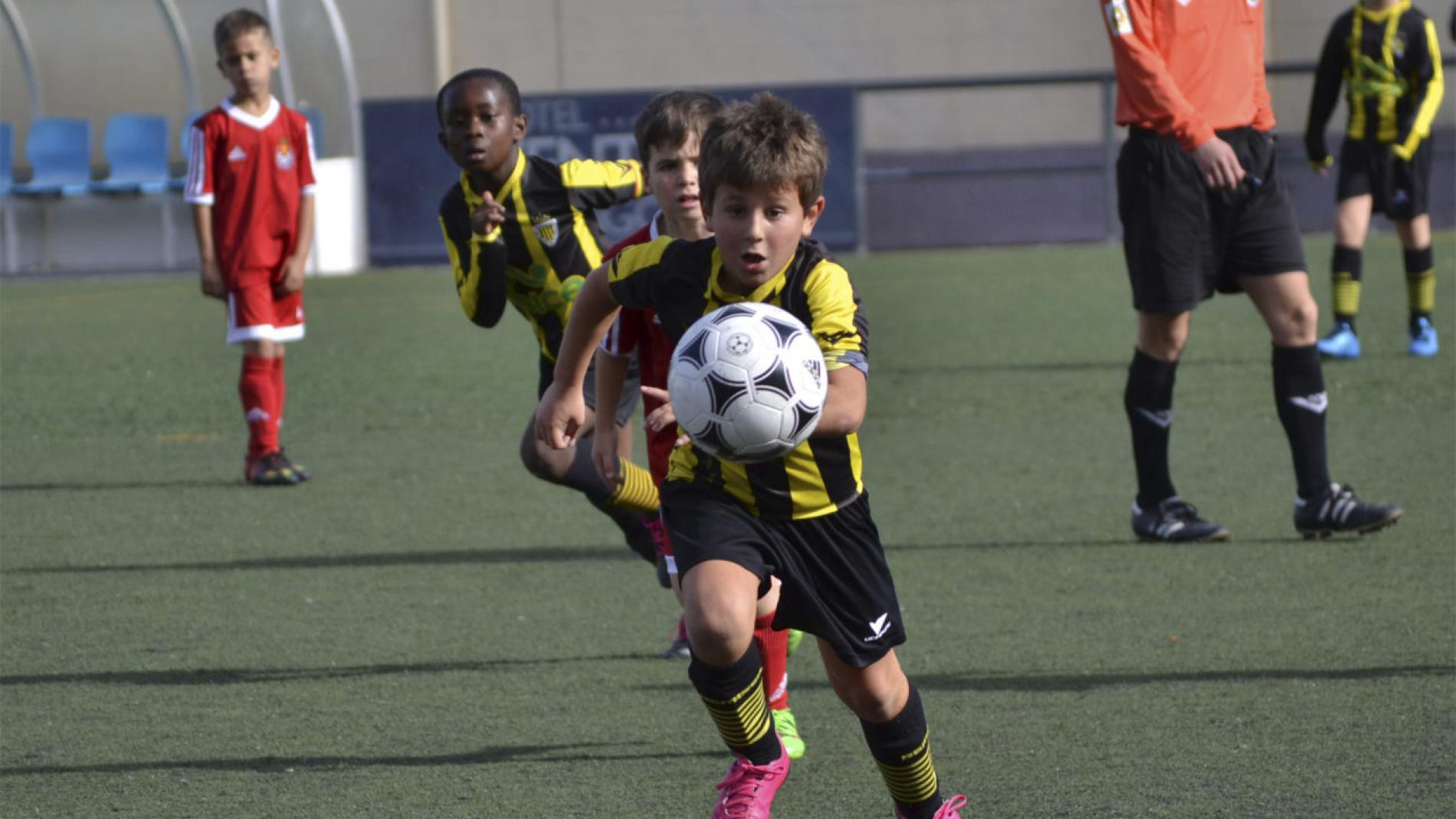 Juego De Fútbol De Observación Del Niño Foto de archivo - Imagen