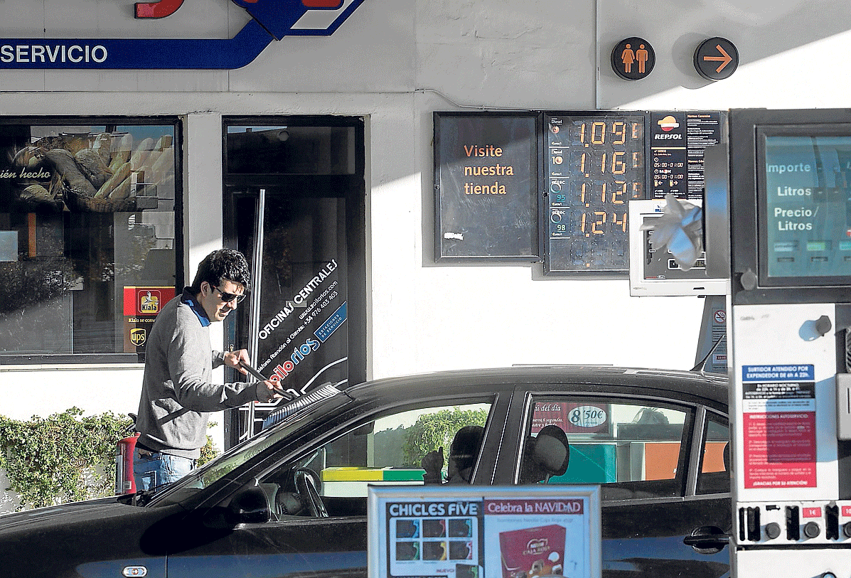 Un conductor limpia el parabrisas tras llenar ayer el depósito en una gasolinera de Zaragoza