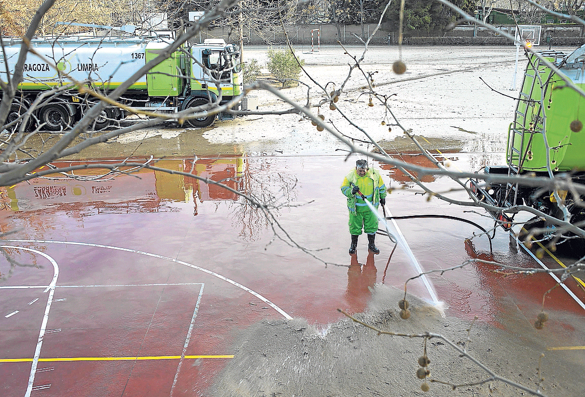 Vuelta al colegio. El colegio Jerónimo Zurita de Zaragoza reabrió ayer tras una semana cerrado por inundaciones en la foto, un operario ultima la limpieza del patio. También volvieron a clase los escolares de Boquiñeni